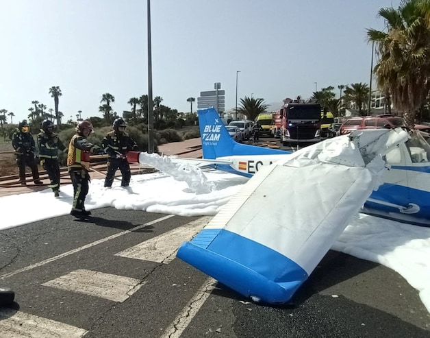 Firefighters spray firefighting foam on the road surface after fuel leaked from the plane.