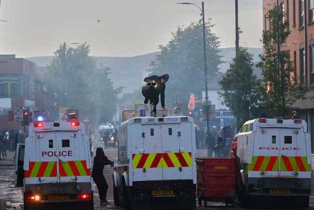 Manifestants vallen politiebusjes aan.