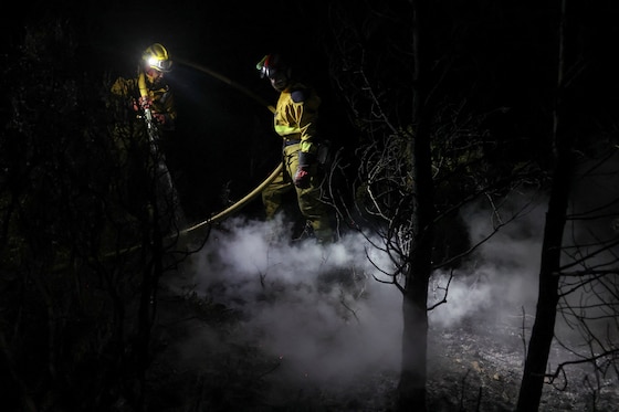Des pompiers luttent contre un incendie de forêt pendant la nuit à Pouzols-Minervois, près de Narbonne.