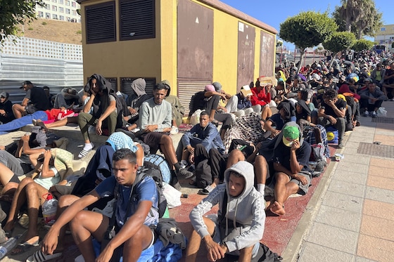Migranten staan aan te schuiven bij een tijdelijk opvangcentrum.