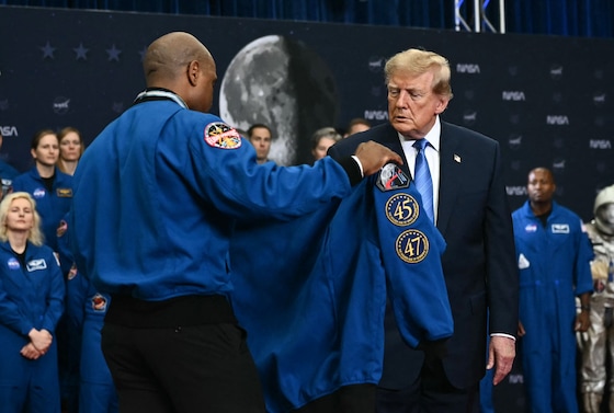 NASA-astronaut Victor Glover geeft de Amerikaanse president Donald Trump een jas nadat hij en zijn collega-astronauten een onderscheiding van de president hadden ontvangen.