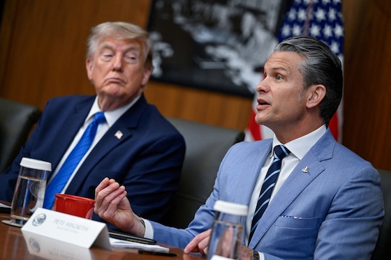 Oorlogsminister Pete Hegseth naast Trump.