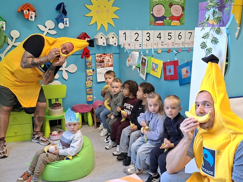 Vrijwilligers verkleed als banaan delen eerlijk fruit uit in scholen in Meerhout