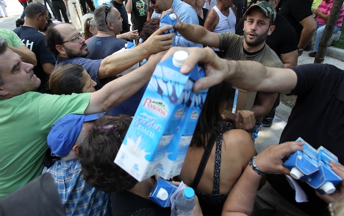 Leden van de Griekse neonazipartij 'Gouden Dageraad' delen melk uit in Athene. De militanten delen enkel voedsel uit aan autochtone Grieken.