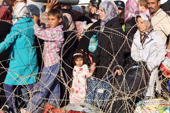 Syrische vluchtelingen staan in de rij bij de Turkse grens.
