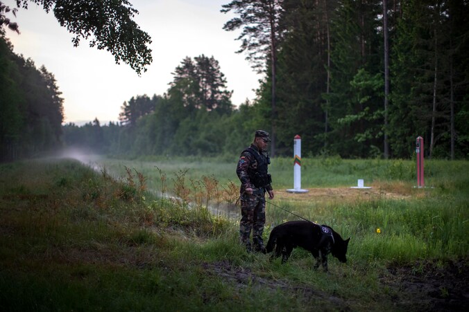 Archiefbeeld 10 juni 2021: een agent van de Litouwse grenswacht aan de grens met het buurland Wit-Rusland. Vanaf nu zal ook het leger aan de grens worden ingezet. 