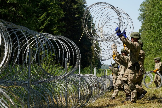 Litouwse soldaten plaatsen prikkeldraad aan de grens met het buurland Wit-Rusland. 
