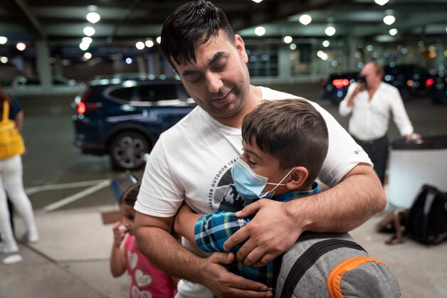 Een vader en zijn zoontje worden herenigd op Minneapolis-St. Paul International Airport, in Minneapolis, nadat een deel van de familie in Kaboel vast kwam te zitten.