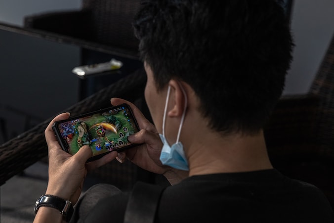 Een Chinese jongeman speelt het populaire spel 'Honor of Kings’ op zijn mobiele telefoon.
