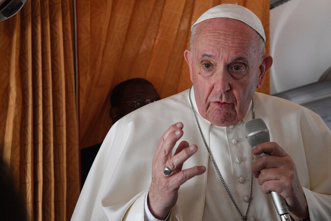 Paus Franciscus spreekt de journalisten toe op het vliegtuig.
