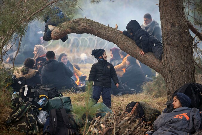 Migranten rusten uit aan de Pools-Wit-Russische grens nabij Grodno, Wit-Rusland.