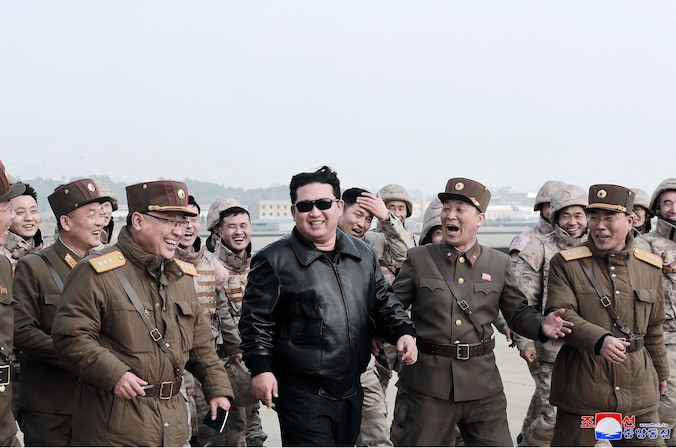 De Noord-Koreaanse leider Kim Jong-un in het gezelschap van militairen voor de lancering van een ballistische raket.