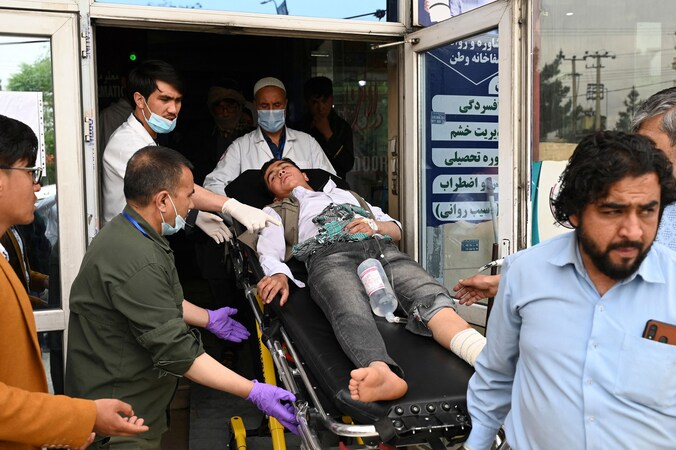 Gewonden worden overgebracht naar het ziekenhuis na de aanslag op de jongensschool in Kabul.