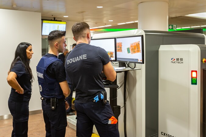 Douanepersoneel op Brussels Airport bij een scanner van het Chinese merk Nuctech. Archiefbeeld.