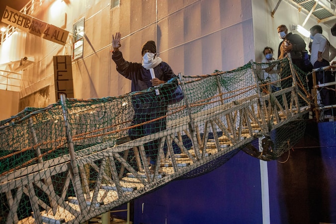Migranten verlaten de Geo Barents in de haven van Catania.