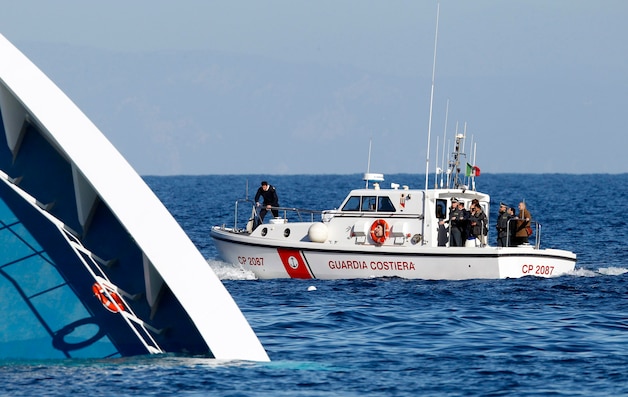 Italiaanse reddingswerkers zoeken naar overlevenden op zee.