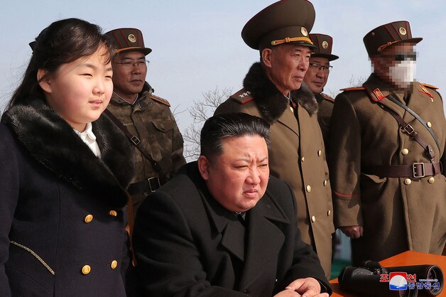 De Noord-Koreaanse leider Kim Jong-un en zijn dochter (links) kijken naar een raketlancering.