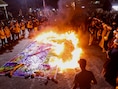 Aanhangers van de Iraakse sjiitische geestelijke Moqtada al-Sadr verbranden een holebi-vlag tijdens een protest tegen een man die een koran heeft verbrand buiten een moskee in Stockholm, in Bagdad, Irak, 12 juli 2023
