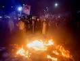 Aanhangers van de Iraakse sjiitische geestelijke Moqtada al-Sadr verbranden een holebi-vlag tijdens een protest tegen een man die een koran heeft verbrand buiten een moskee in Stockholm, in Bagdad, Irak, 12 juli 2023.