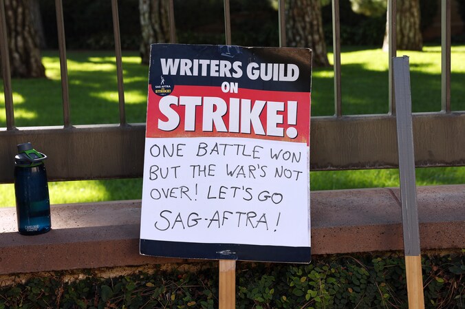 Op een protestbord van schrijversvakbond WGA wordt steun uitgesproken voor acteursvakbond SAG-AFTRA.