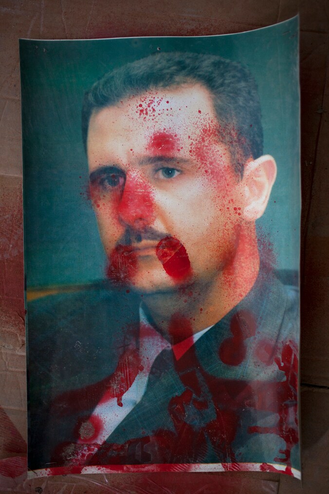 Een met rode verf beklad portret van Assad.