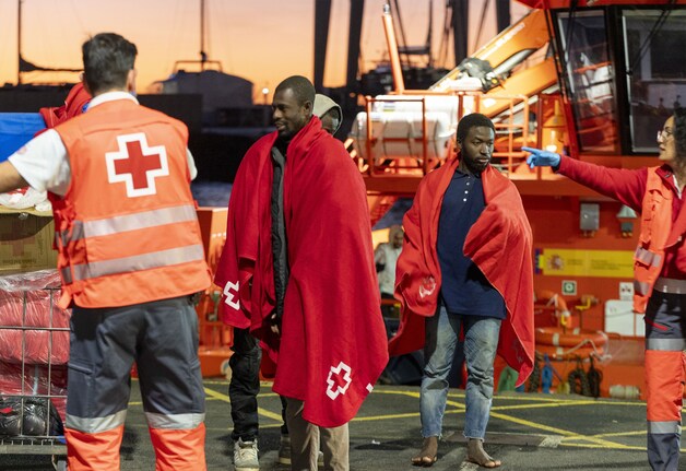 Rode Kruis en Reddingsmarineleden helpen migranten die op zee zijn gered bij aankomst in de haven van Lanzarote, Spanje. 