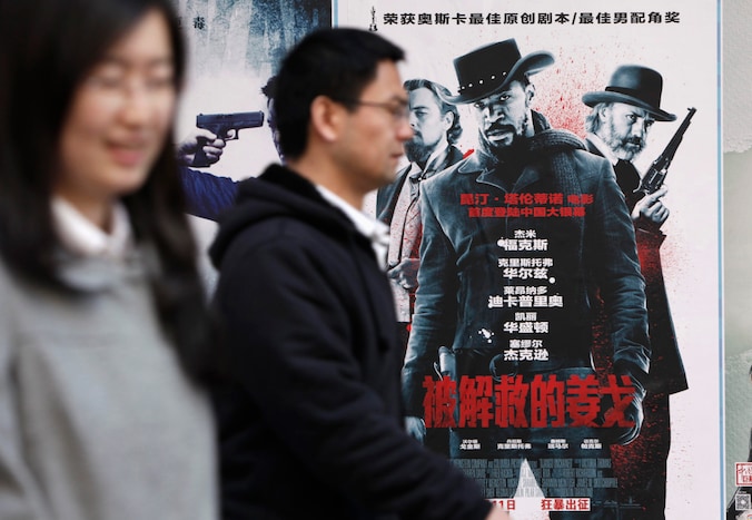 Mensen wandelen voorbij een poster van 'Django Unchained' aan een bioscoop in Peking.