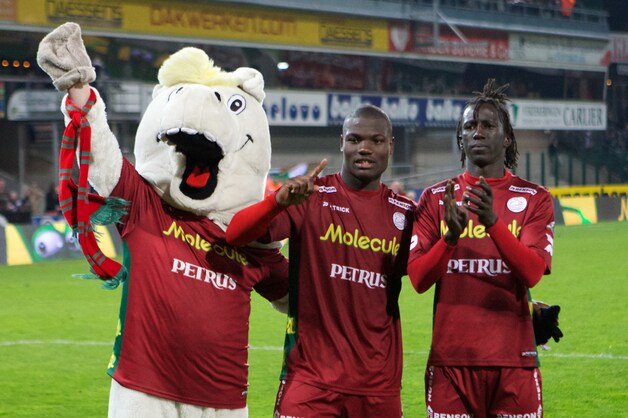 De mascotte viert met doelpuntenmakers Leye en Malanda.
