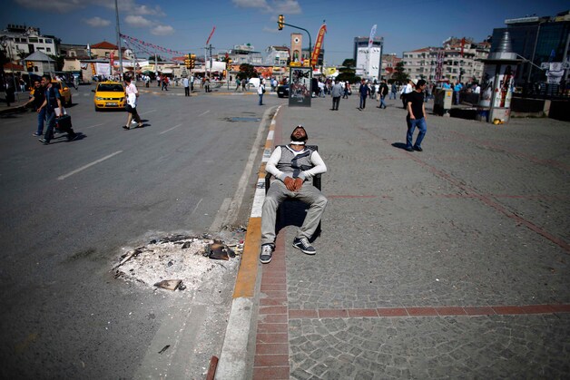 Een Turkse demonstraat slaapt midden op het Taksim-plein in het centrum van Istanbul.