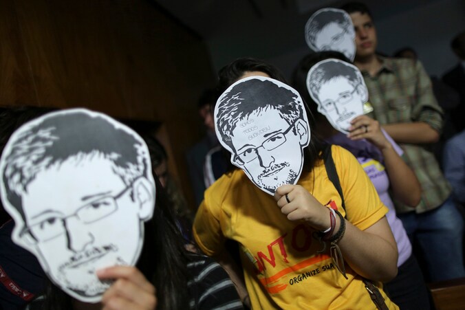 Brazilianen met het portret van NSA-klokkenluider Snowden bij wijze van protest.