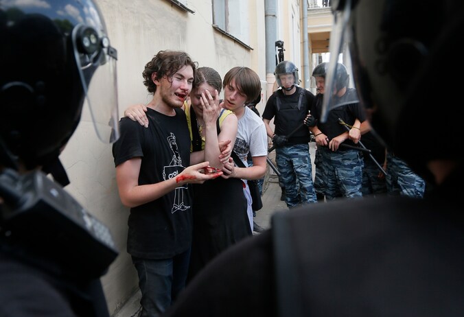 Homo-activisten worden door de oproerpolitie beschermd nadat ze zijn aangevallen tijdens een demonstratie in Sint Peterburg, eind juli.