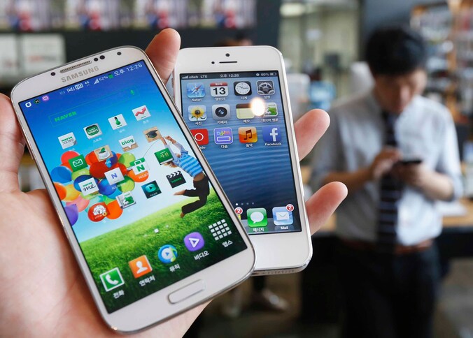 Een Samsung Galaxy S4 (L) en een iPhone 5.
