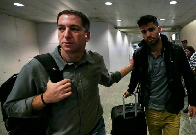 Guardian-journalist Glenn Greenwald (L) loopt met zijn partner David Miranda (R) op het vliegveld van Rio de Janeiro