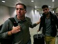 Guardian-journalist Glenn Greenwald (L) loopt met zijn partner David Miranda (R) op het vliegveld van Rio de Janeiro