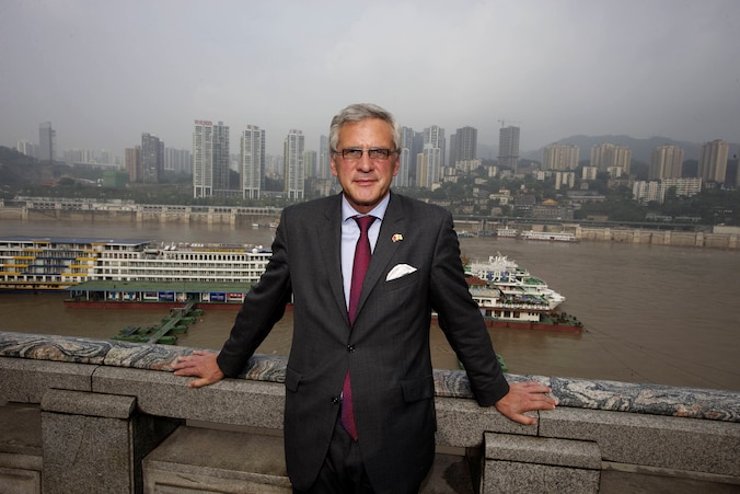 Kris Peeters poseert voor de skyline van Chongqing.