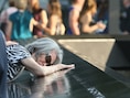 Mija Quigley vleit zich op de naam van haar zoon Patrick Quigley op de gedenksteen aan het nieuwe One World Center in New York. Quigley was een passagier op het eerste vliegtuig dat zich in het World Trade Center boorde.