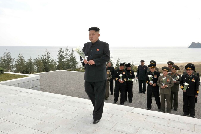 Kim Jong-un legt bloemen bij een gedenkteken voor de slachtoffers.
