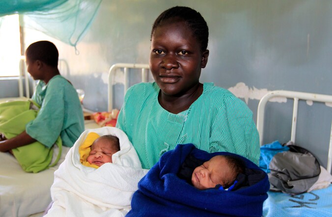 Een trotse Millicent Owuor, met links Barack Obama en rechts Mitt Romney