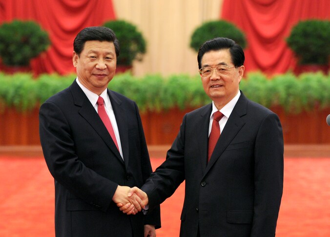 Hu Jintao (r.) schudt de hand van zijn opvolger Xi Jinping (l.).