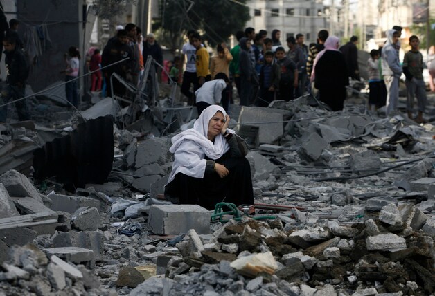 Een Palestijnse vrouw zit tussen het puin na een bombardement op een vluchtelingenkamp in Rafah.
