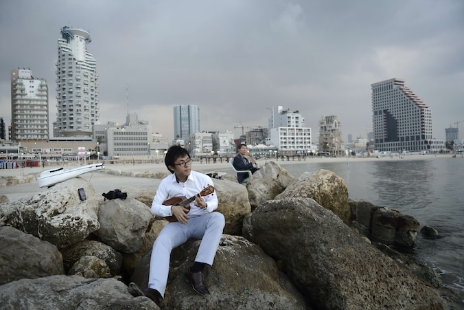 Een toerist op het strand in Tel Aviv, net nadat de wapenstilstand werd afgekondigd.