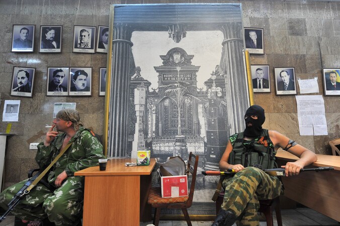 Pro-Russische separatisten rusten uit in een regeringsgebouw in Donetsk dat ze zojuist hebben ingenomen.