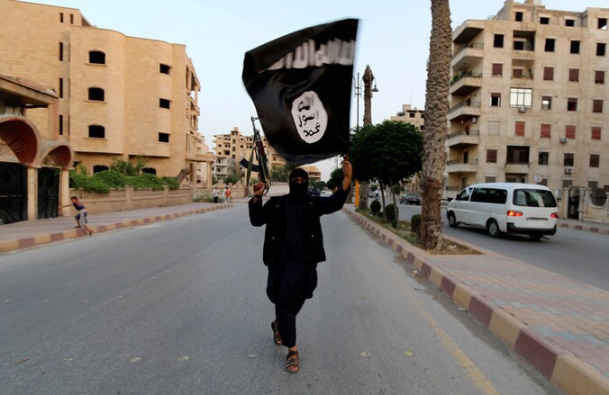 Een man zwaait met de vlag van ISIS in de Syrische stad Raqqa.