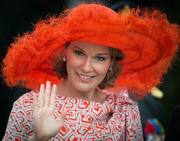 Steeds goed, zo'n hoed: op 21 juli 2014 - ze zit dan exact een jaar op de troon - verschuilt de koningin zich onder een oranje hoed. Daarmee zit ze sowieso goed: hij biedt beschutting tegen zon én de gewoonlijke 'drache nationale'.