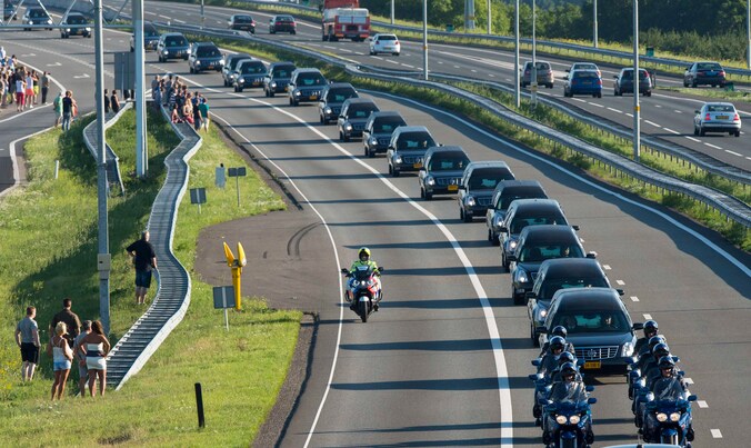 Een colonne lijkwagens met daarin de lichamen van tientallen slachtoffers van MH17 rijdt naar Hilversum.
