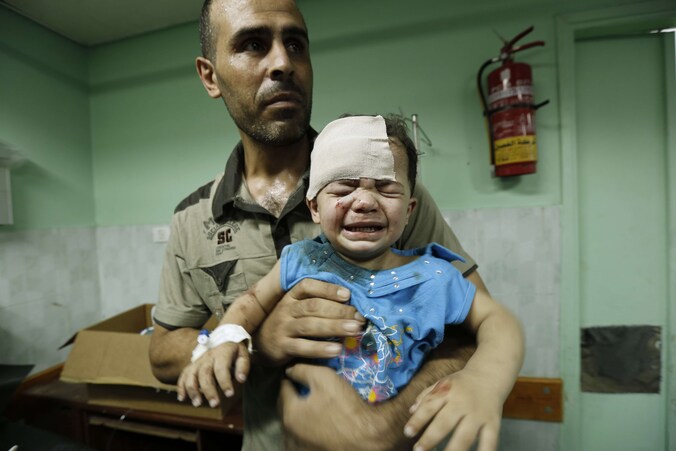 Een Palestijnse man met zijn kind, dat gewond raakte tijdens een Israëlische luchtaanval.