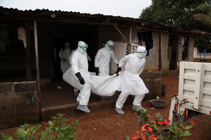 Liberiaanse verpleegsters halen het lichaam op van een patiënt die overleden is aan ebola. Pas sinds twee dagen zijn de begravingen goed op gang gekomen.