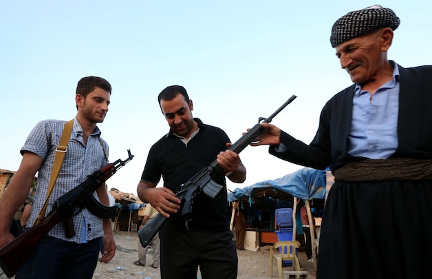 Koerdische strijdkrachten in Irak inspecteren een M16-geweer op een wapenmarkt in Erbil.