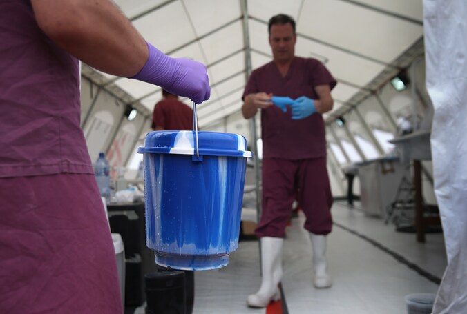 Een Amerikaanse wetenschapper overhandigt bloedstalen van vermoedelijke ebola-patiënten in een laboratorium nabij Monrovia.