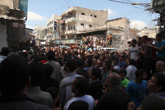 Palestijnen kijken toe hoe militanten van Hamas de vermoedelijke collaborateurs in het openbaar executeren.